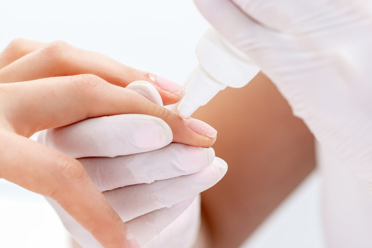 Applying nail glue to a natural nail with a precision applicator